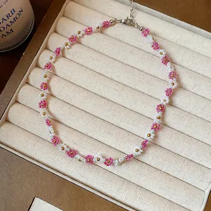 Gros plan d'un collier de fleurs en perles de verre roses et blanches