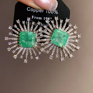 Detailed view of luxury sunburst zircon stud earrings with a square green center stone