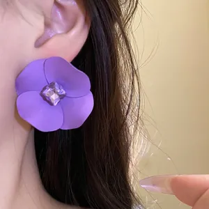 Elegantes pendientes de flor morada mate con un brillante centro de cristal