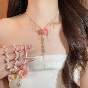 Dettaglio di un elegante girocollo con ciondolo a rosa rosa e perle di cristallo fini