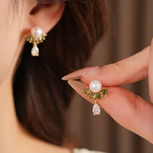 Dettaglio orecchini di perle placcati oro 18k con zirconi verdi e trasparenti a goccia