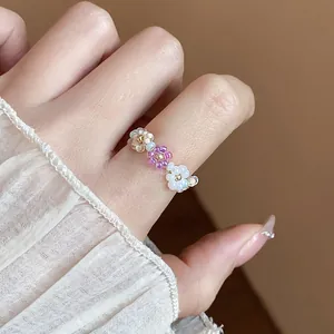 Détail d'une bague fleur en perles faite main portée au doigt pour un style tendance