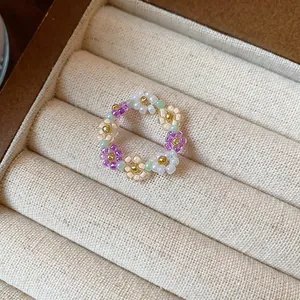 Vue détaillée d'une bague fleur en perles de verre colorées faite main dans un écrin