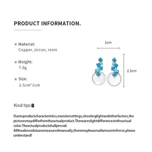 Product detail view of silver earrings with blue resin stones and pearl-like drops