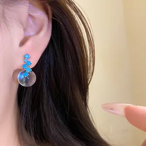 Detail view of silver needle zircon resin round pendant earrings in minimalist style