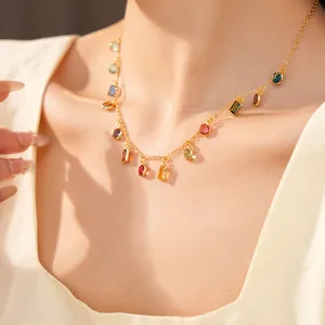 Primo piano di collana placcata oro 18 carati con ciondoli in zircone colorato sul collo.