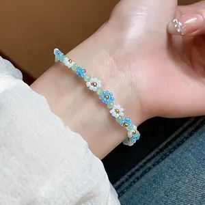 Gros plan d'un bracelet de perles fait main avec de délicats détails floraux au poignet.