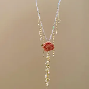 Vista dettagliata della collana elegante con pendente rosa stabilizzata e perle d'oro