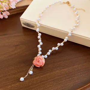 Dettaglio elegante di un ciondolo con rosa stabilizzata su una delicata collana di perle