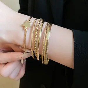 Close-up of vintage gold star bangle set with textured and smooth finishes on wrist