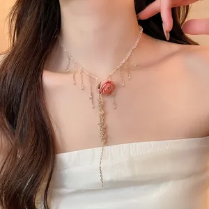 Primo piano della collana con pendente rosa stabilizzata, perle rosa e frange dorate