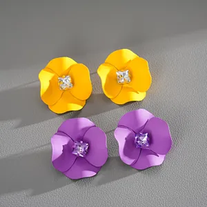 Detail view of colorful matte painted flower stud earrings with square center rhinestones