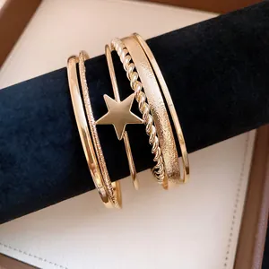 Detailed view of vintage gold star cuff bracelet set with twisted and textured bands