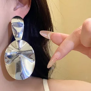 Large shiny metallic oval drop earrings with silver needles for a minimalist style