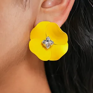 Detailed close-up showing yellow matte flower stud earring with a square crystal center