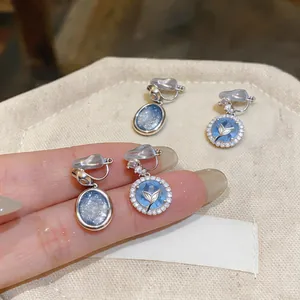 Primo piano di eleganti orecchini a clip blu cielo stellato in stile francese