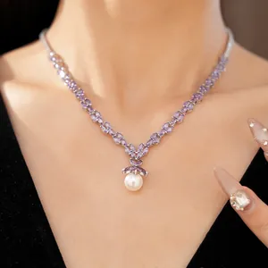 Detailed view of an elegant purple zircon leaf necklace featuring a white pearl pendant.