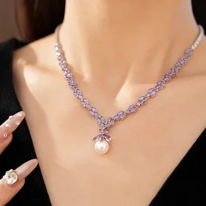 Detail shot of purple marquise zircon necklace with white pearl pendant on model.