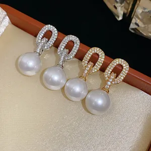 Close-up view of French-style pavé zircon oval earrings with elegant large dangling pearls.
