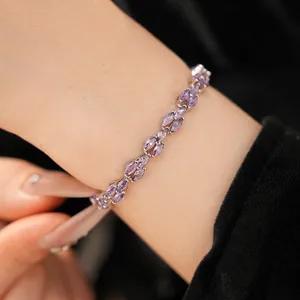 Close-up of an elegant silver bracelet featuring purple marquise zircon stones on a wrist