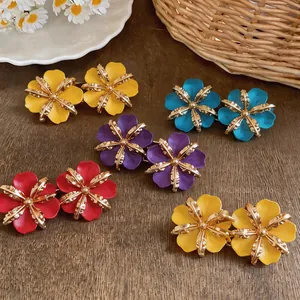 Colorful enamel flower stud earrings with metallic centers in various vibrant shades.