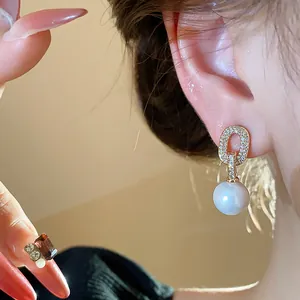Detailed close-up of French style oval zircon stud earring with a white pearl dangle