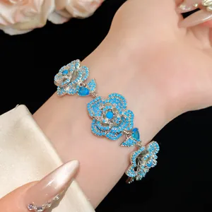 Primo piano di un elegante bracciale in zircone a fiori blu indossato sul polso di una donna