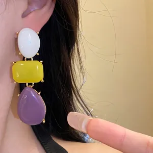 Elegant vintage resin drop earrings with multi-colored geometric pendants shown on model