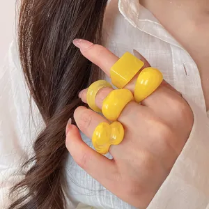 Detailed close-up view of a vibrant yellow candy-colored resin ring set worn on a hand