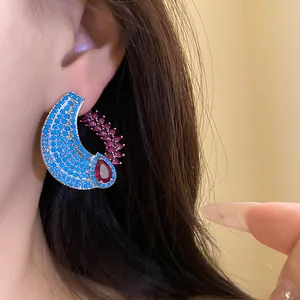 Dettaglio orecchino a mezzaluna elegante con pietre blu e zircone rosso a goccia