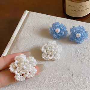 Elegantes pendientes de flores hechos a mano con perlas en colores azul y blanco