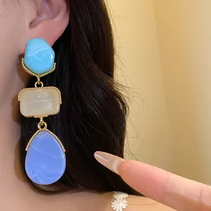 Gros plan détaillé montrant des boucles d'oreilles vintage en résine sur une oreille