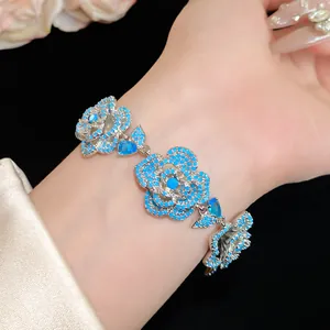 Primo piano di un elegante bracciale floreale con zirconi blu indossato sul polso di una modella