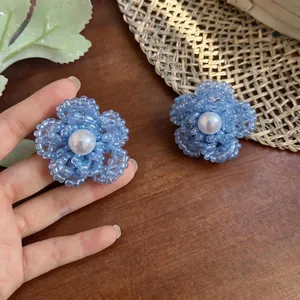 Elegantes pendientes de flor de cuentas azules con perla central en un dulce estilo francés.