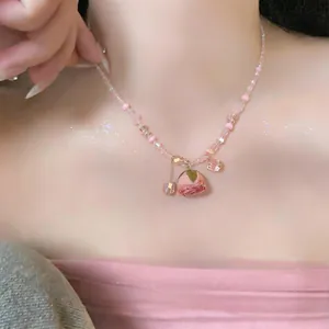 Détail d'un collier en perles avec un pendentif en rose séchée rose sur un modèle