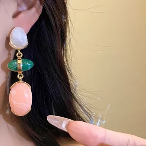 Close-up detail of retro multi-color resin oval drop earrings with gold-tone accents.