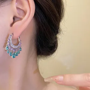 Exquisite zircon hoop earrings featuring purple and teal water-drop pendants on female model