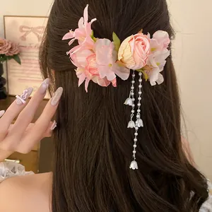 Dettaglio del fermaglio per capelli floreale con nappe di perle su capelli castani