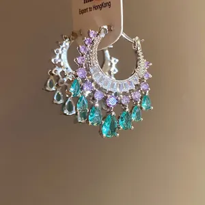 Elegant silver hoop earrings featuring purple zircons and teal waterdrop pendants