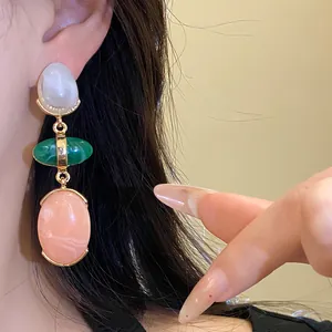 Close-up detail of vintage resin oval pendant earrings with colorful stones