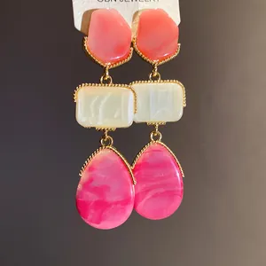 Gros plan de boucles d'oreilles en résine de style cour vintage avec cadre doré torsadé