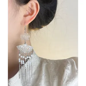 Close-up of elegant New Chinese style lotus earrings with long silver tassels and beads