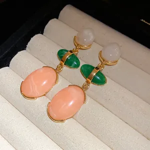 Macro detail view of vintage multi-color resin drop earrings on a jewelry display tray.