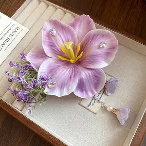 Primo piano di fermaglio per capelli a fiore viola con perle e dettagli nappa eleganti