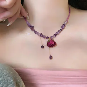 Vue détaillée d'un collier de perles violettes avec un pendentif rose séchée réelle