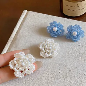 Detalle de pendientes de flores con cuentas hechos a mano y centro de perla suave