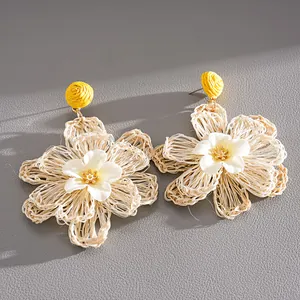 Detailed close-up of handmade woven raffia flower earrings for a summer vacation look