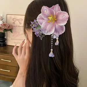 Dettaglio di un fermaglio per capelli a fiore viola con lunghe nappe di perle