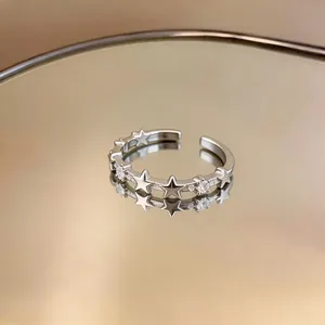 Close-up of elegant silver open ring with zircon stars and minimalist design.