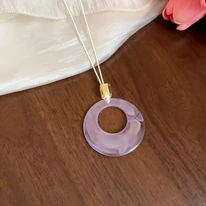 Dettaglio della collana con ciondolo in acrilico marmorizzato viola e corda